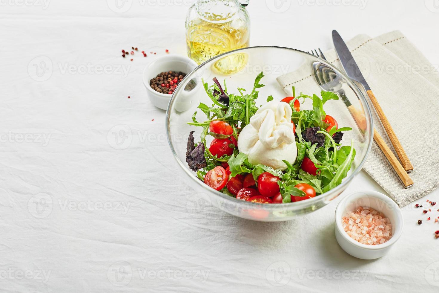 burrata, fromage frais italien à base de crème et de lait de bufflonne ou de vache, avec salade de tomates, roquette et basilic rouge photo