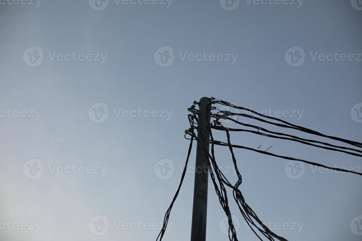 fils électriques sur poteau. de nombreux fils contre le ciel. photo