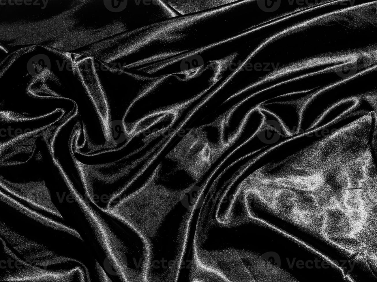 soie noire de luxe ou fond de texture satinée avec vague liquide ou plis ondulés. conception de papier peint photo