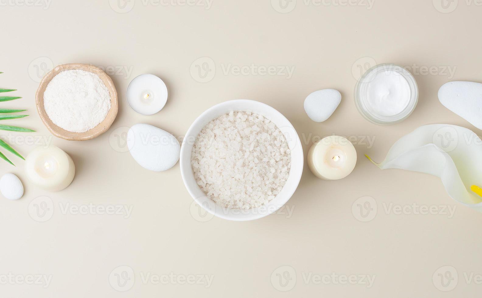 composition de spa avec produits de soin de la peau, pierres, bougies et feuilles de palmier sur beige pastel. mise à plat, espace de copie photo