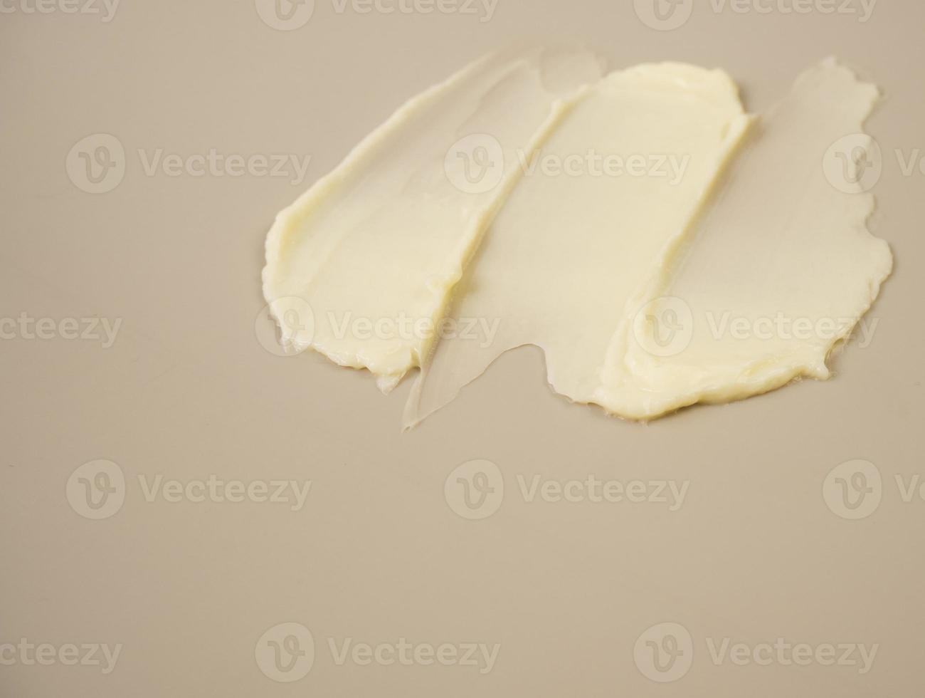 produits cosmétiques tache de texture jaune crème fond beige nude. la texture du masque capillaire cosmétique naturel, crème, gommage. photo