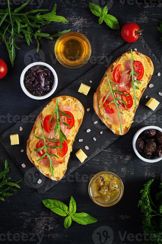 bruschetta grillée avec rillettes de poulet, jambon et herbes. délicieux toasts avec pâté de poulet et différents apéritifs photo