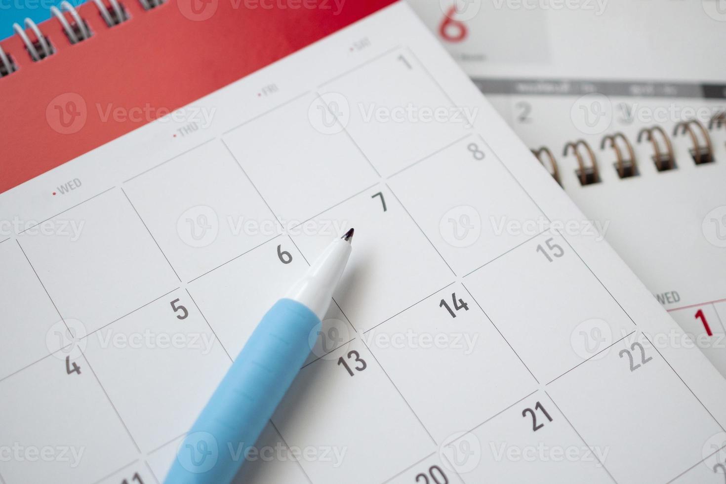 page de calendrier avec stylo gros plan sur fond bleu concept de réunion de rendez-vous de planification d'entreprise photo