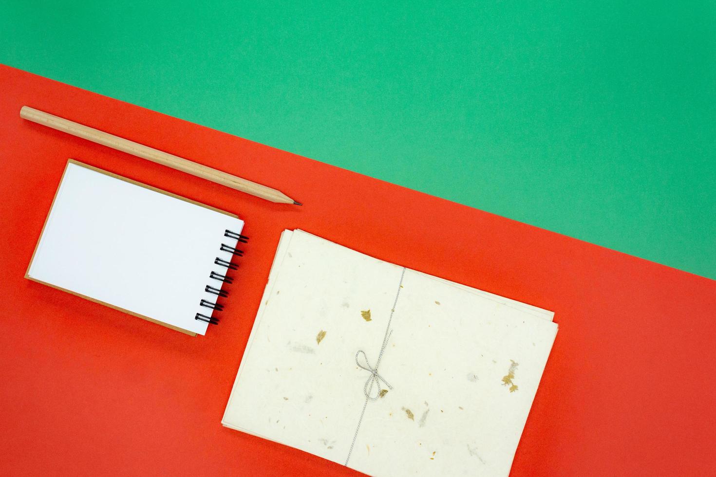 concept de noël ou de vacances. mini bloc-notes en spirale vierge blanc, crayon en bois et ensemble d'enveloppes. photo
