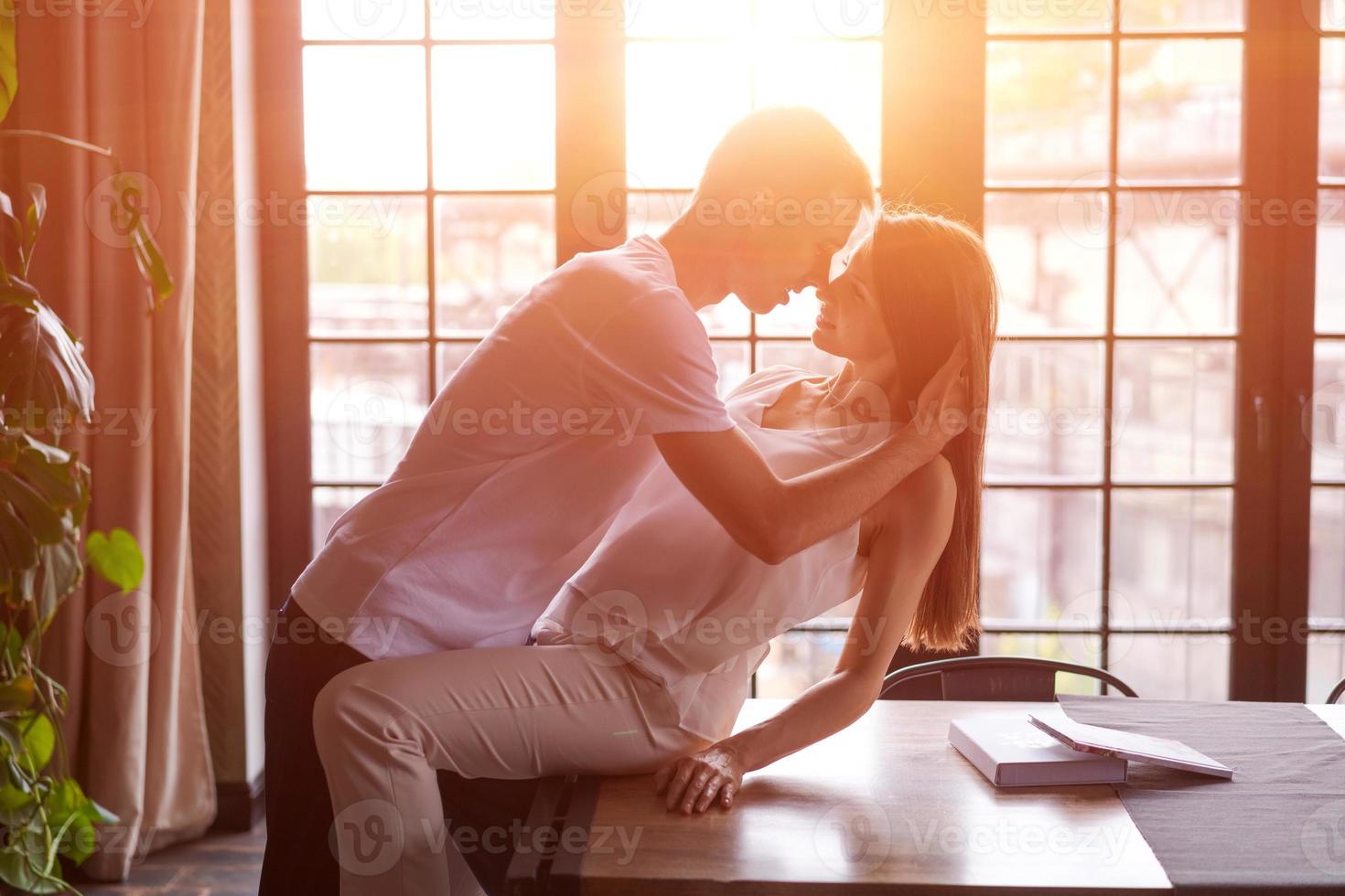 jeune couple passionné dans la chambre contre la fenêtre de fond, la fille est assise photo