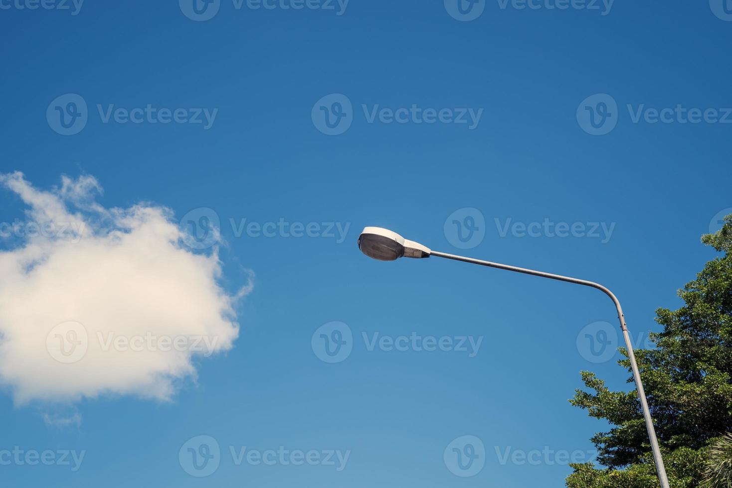 lampadaire électrique moderne avec ciel bleu et nuage en arrière-plan. le lampadaire en acier ou la lanterne sur poteau pendant la journée sont conceptualisés dans l'industrie, la technologie et l'urbanisation photo