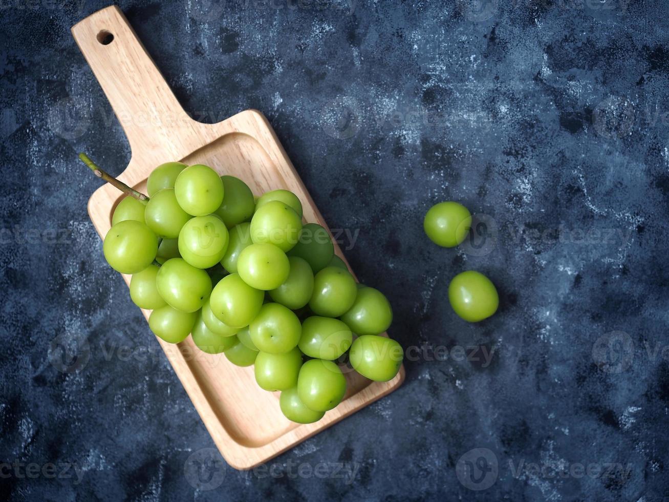 raisins verts japonais ou fruits de raisin muscat brillants vue de dessus sur fond de couleur grise photo