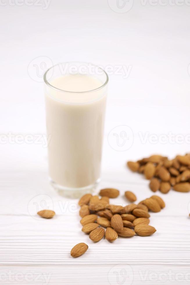 verre de lait d'amande aux noix d'amande sur une table en bois blanche. lait alternatif laitier pour la désintoxication, une alimentation saine et des régimes photo