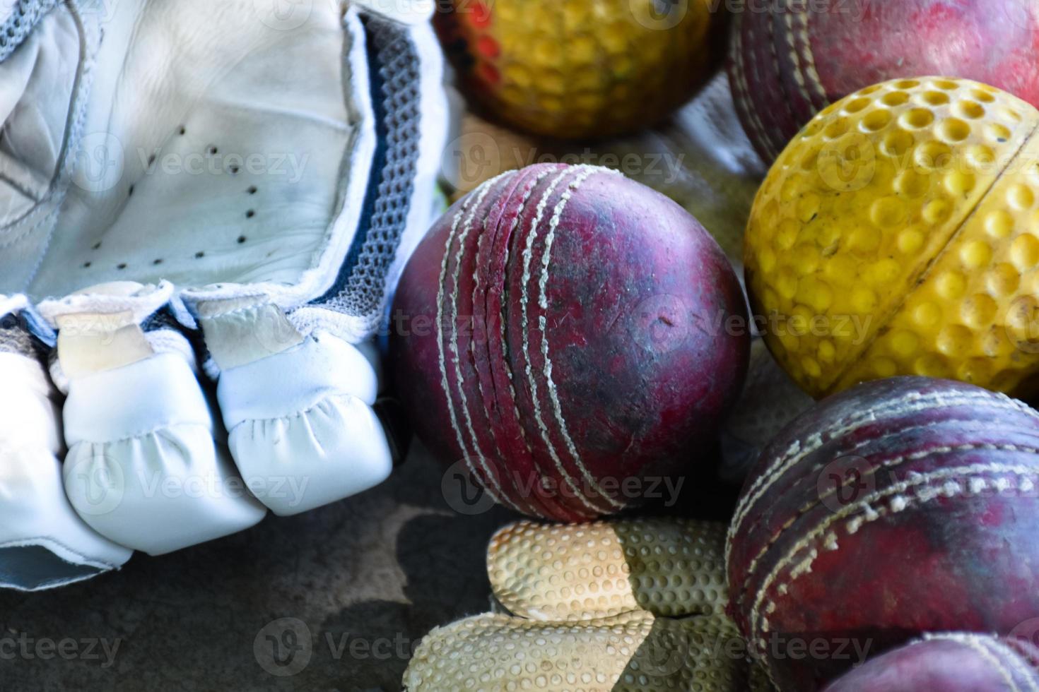 entraînement des équipements de sport de cricket au sol, ballon en cuir, gants et batte, mise au point douce et sélective sur le ballon. photo