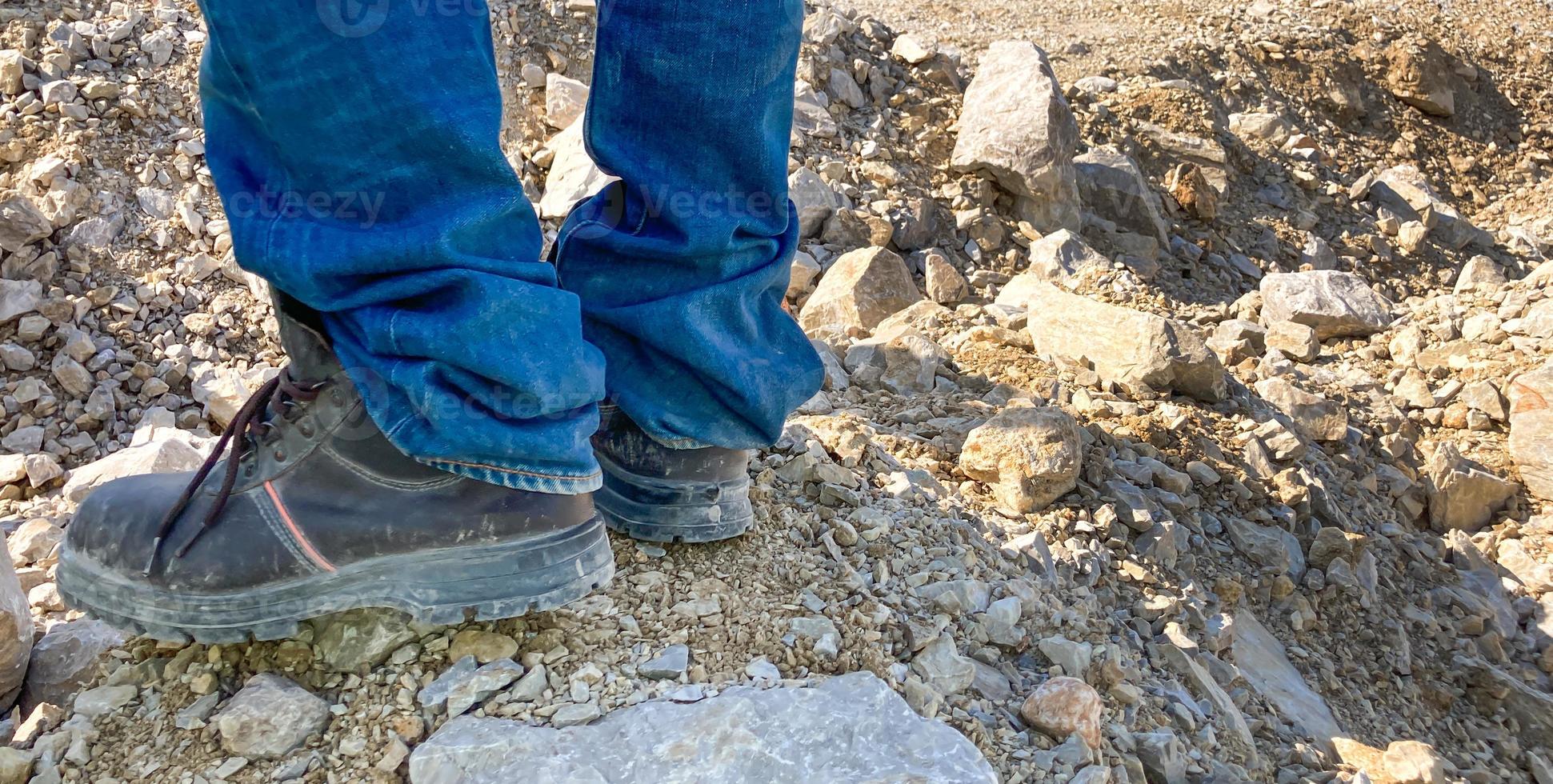 photo de bannière horizontale d'hommes portant des bottes industrielles de travail lourd debout sur le rocher à l'intérieur de la mine industrielle. vêtements de travail durables pour des conditions de travail difficiles pour la protection et la sécurité