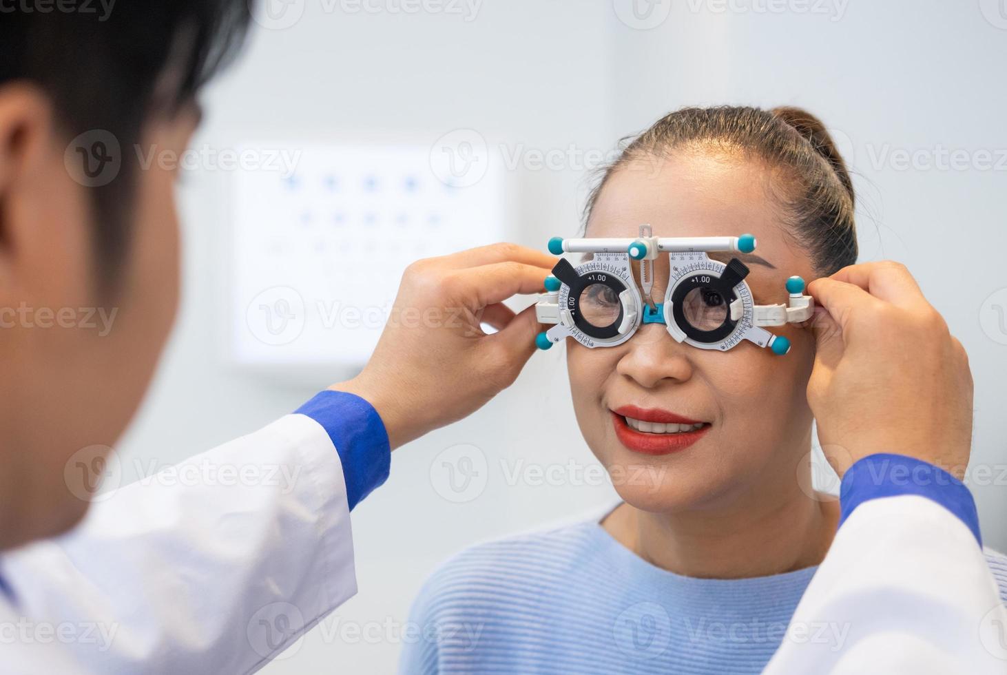 mise au point sélective sur le visage des femmes. tandis que le médecin utilise un équipement d'optométrie et une monture de lunettes d'essai pour examiner le système visuel des yeux des patientes âgées avec une machine et une technique professionnelles. photo