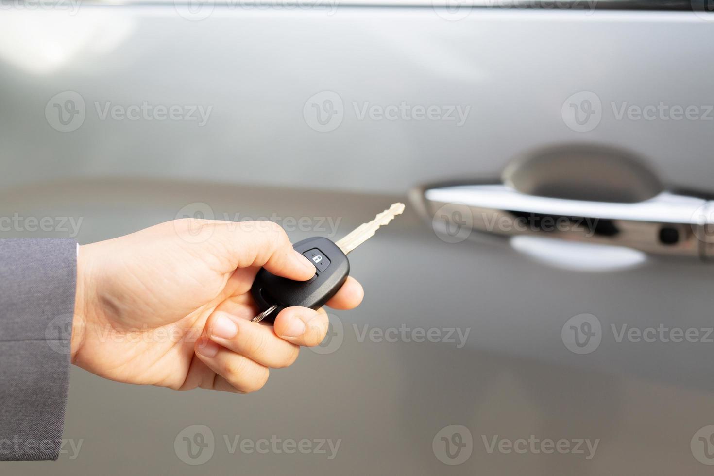 le vendeur porte les clés de voiture livrées au client dans la salle d'exposition avec une offre à faible intérêt. promotion spéciale photo