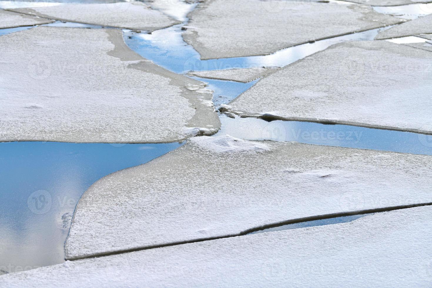 glace fissurée de rivière gelée, eau bleue, texture de glace photo