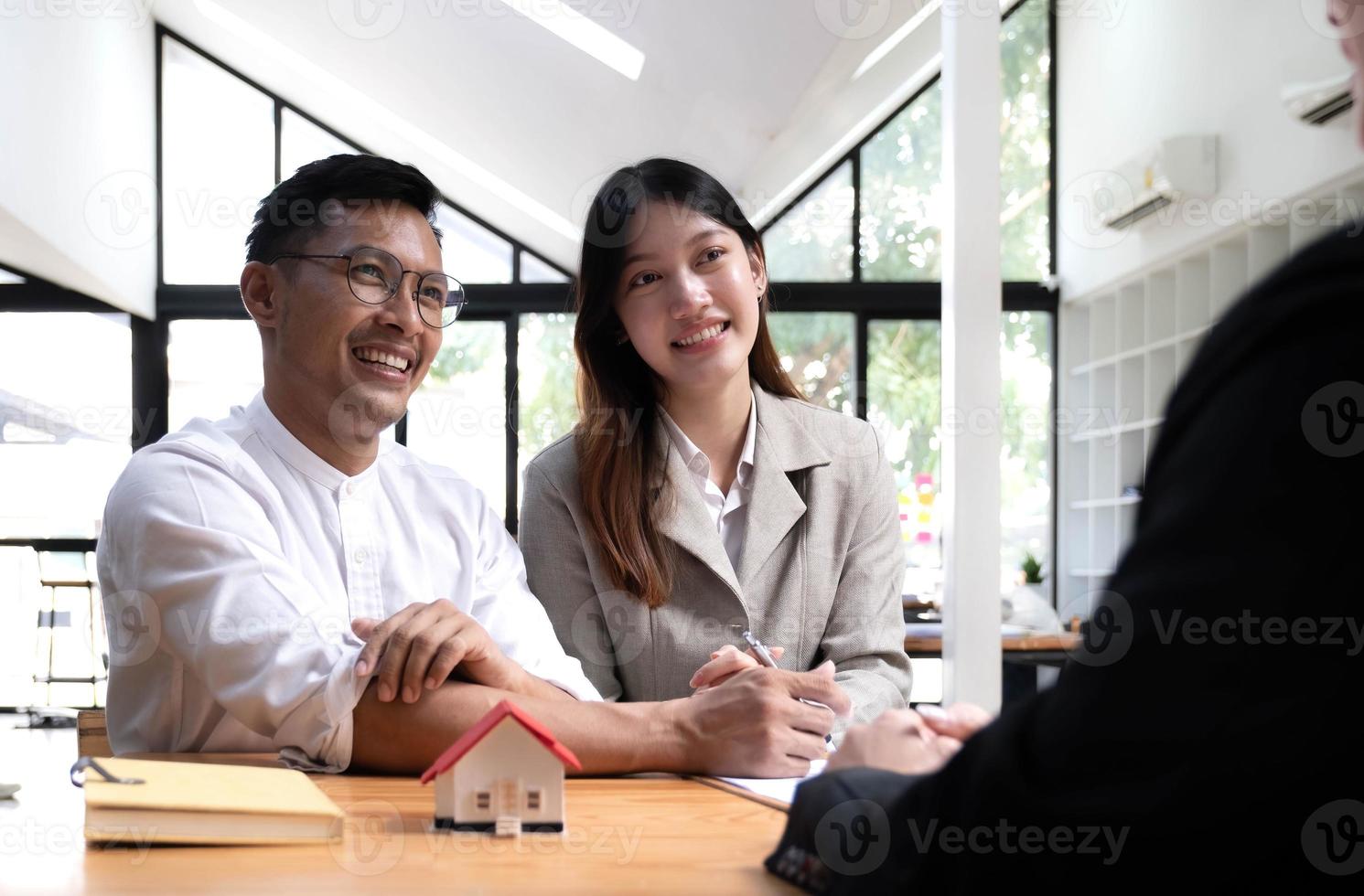 vue horizontale heureux couple marié femme d'origine asiatique mari signant un contrat de location lors d'une réunion avec l'agent immobilier ou le propriétaire, premier achat de propriété, concept de propriété d'hypothèque et de prêt photo