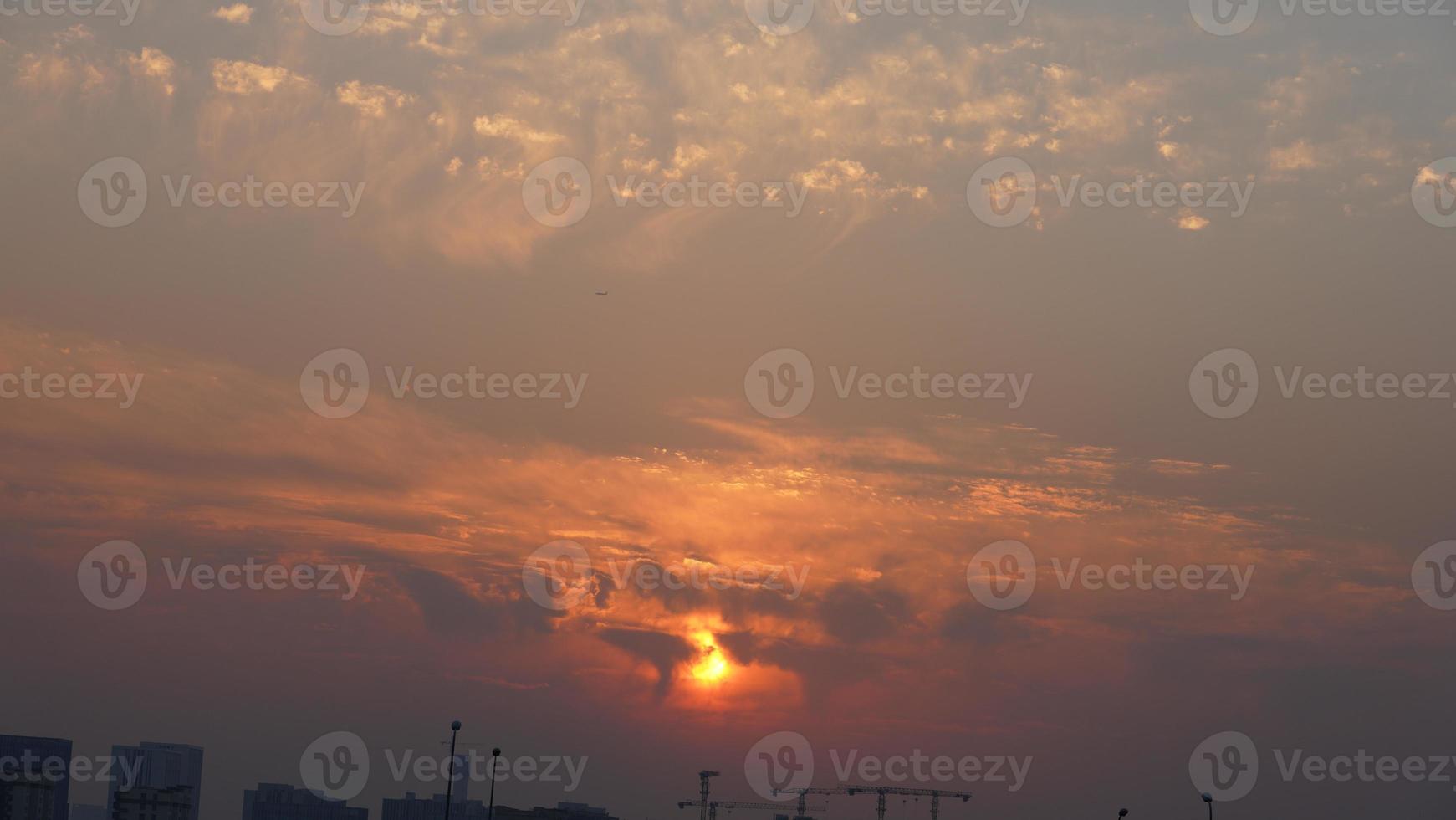 la belle vue sur le coucher du soleil avec les nuages colorés et le ciel de la ville photo