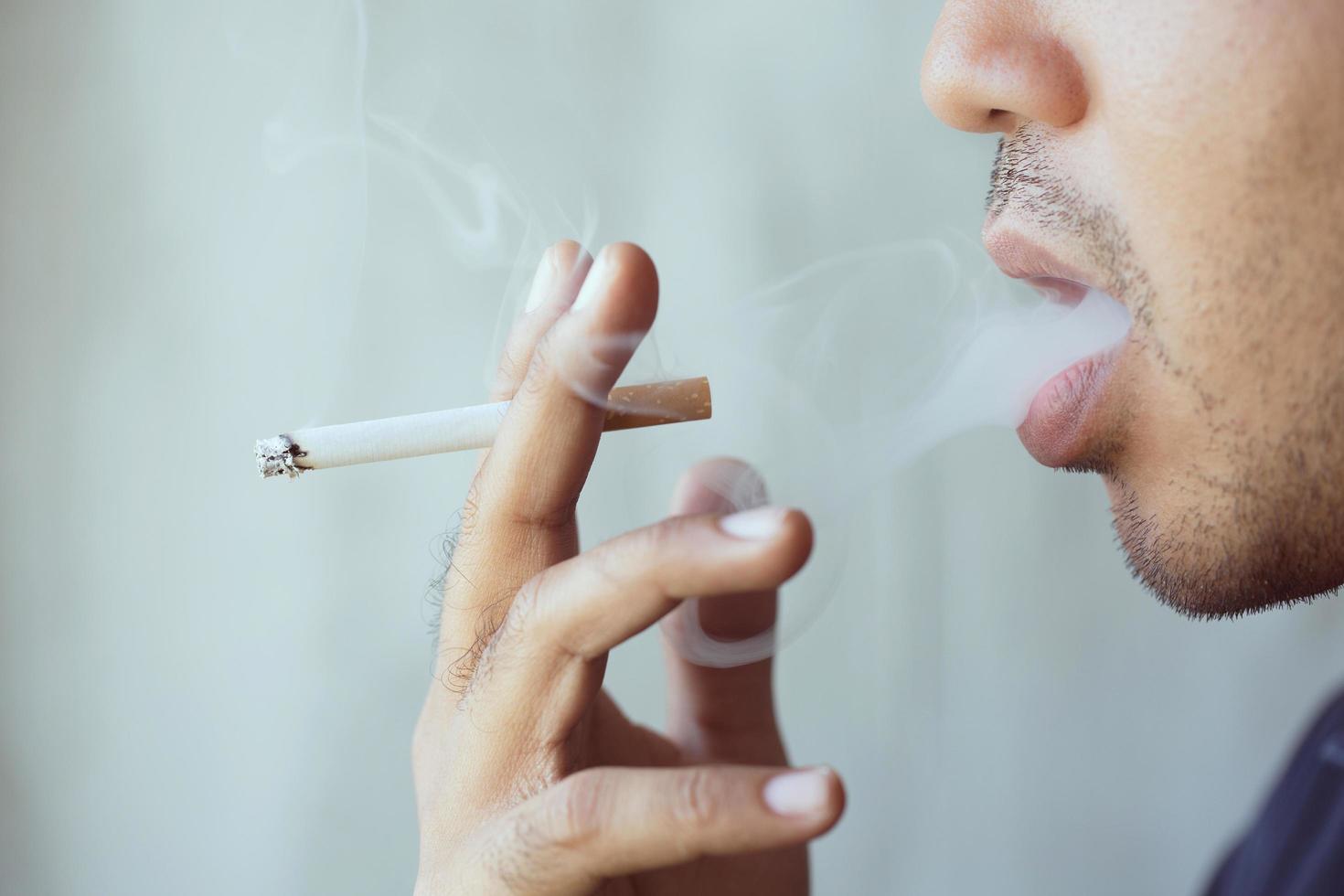 homme fumant une cigarette. propagation de la fumée de cigarette. photo