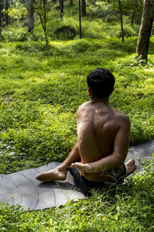 homme vu de près, sans chemise faisant des étirements sur un tapis de yoga, exercice, amérique latine photo