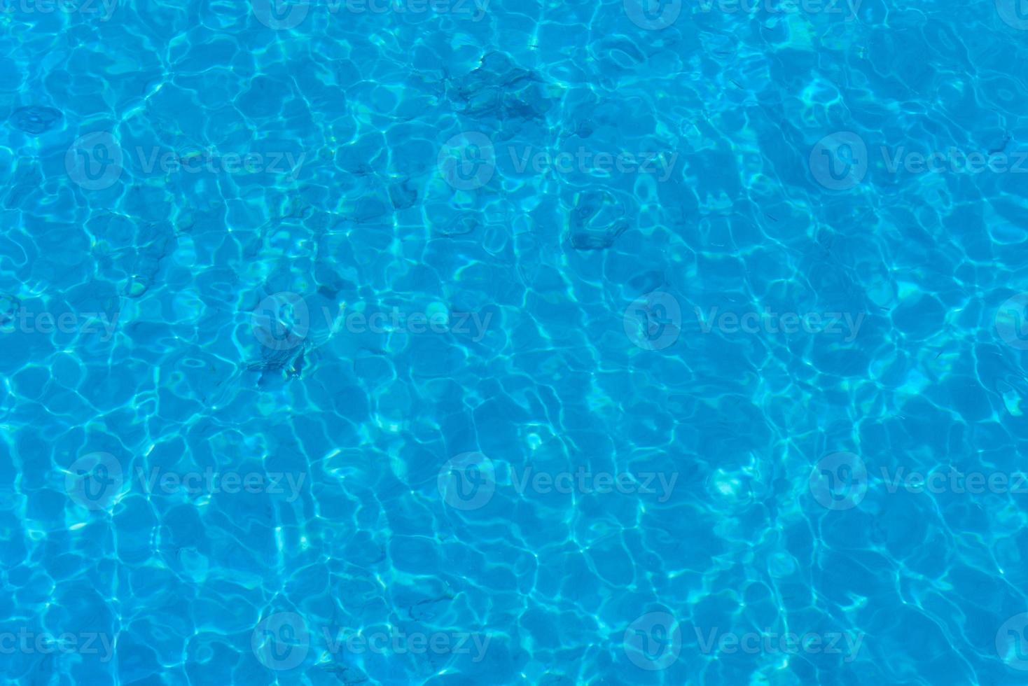 fond d'eau dans une piscine bleue, surface de l'eau avec un reflet du soleil photo