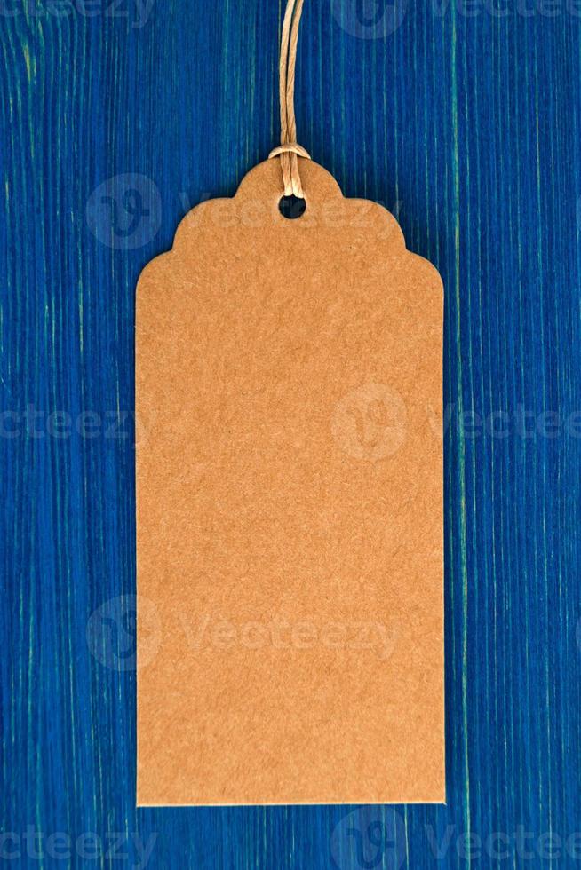 étiquette de prix de papier vierge marron ou étiquette sur le fond en bois bleu, gros plan. photo