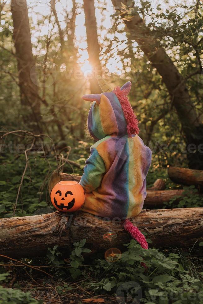 Jolie Petite Fille En Costume De Licorne Arc-en-ciel Pour Halloween Va  Chercher Des Bonbons Dans Un Panier De Citrouilles