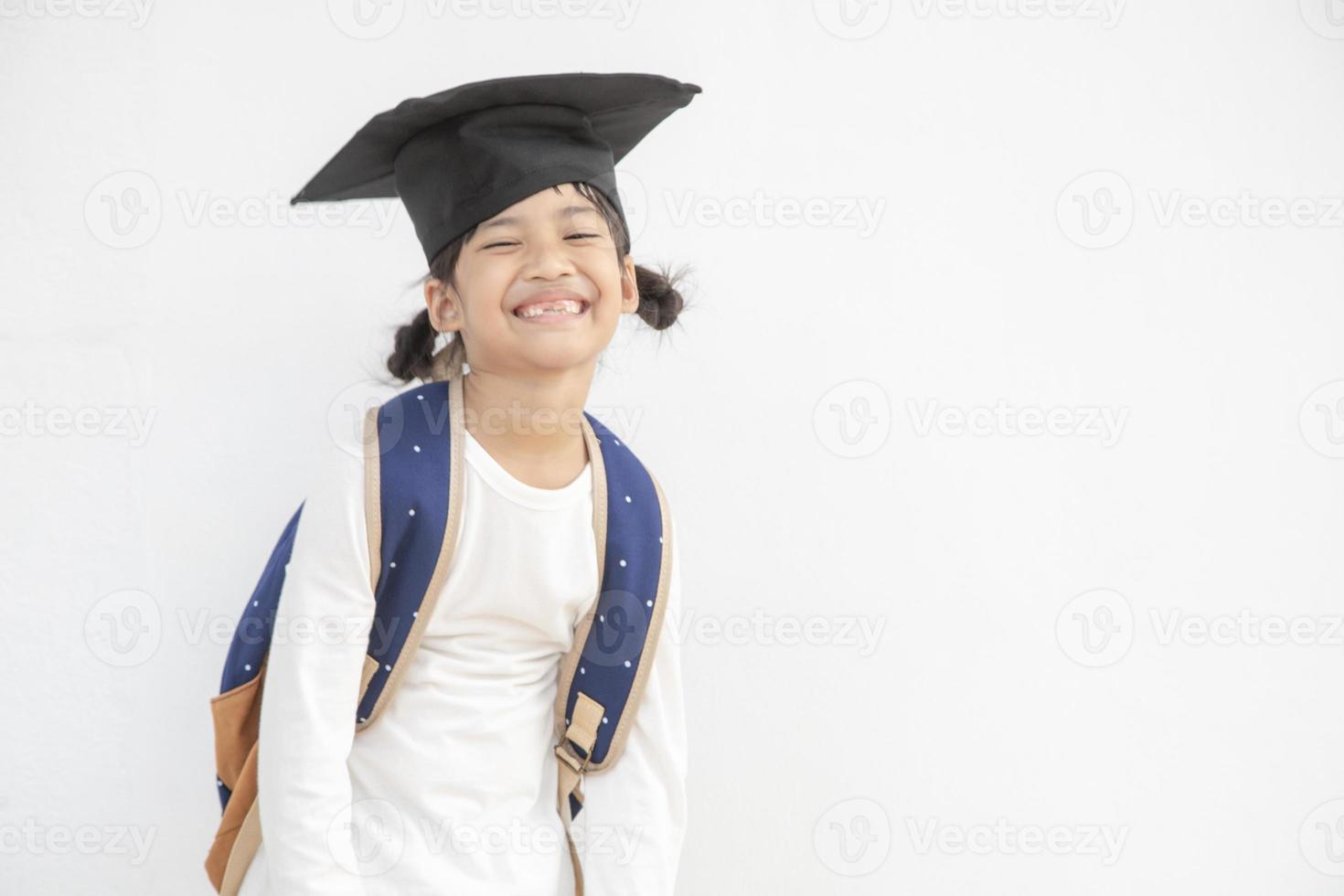 Diplômé d'enfant d'école asiatique heureux avec chapeau de graduation photo
