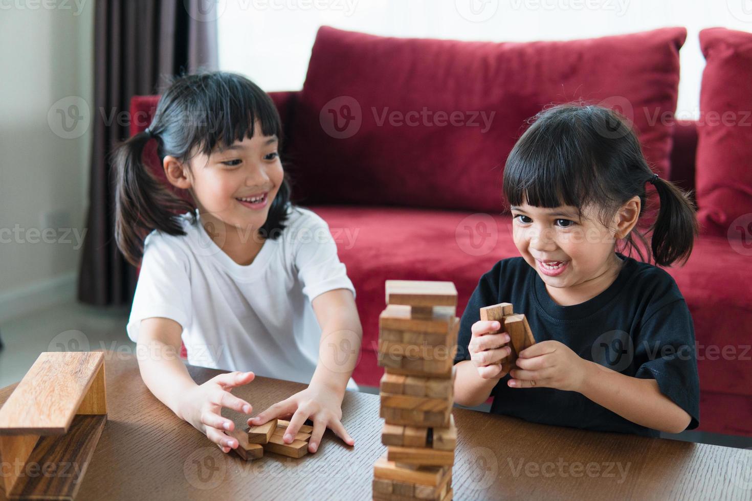 deux filles asiatiques jouant des piles de bois à la maison photo