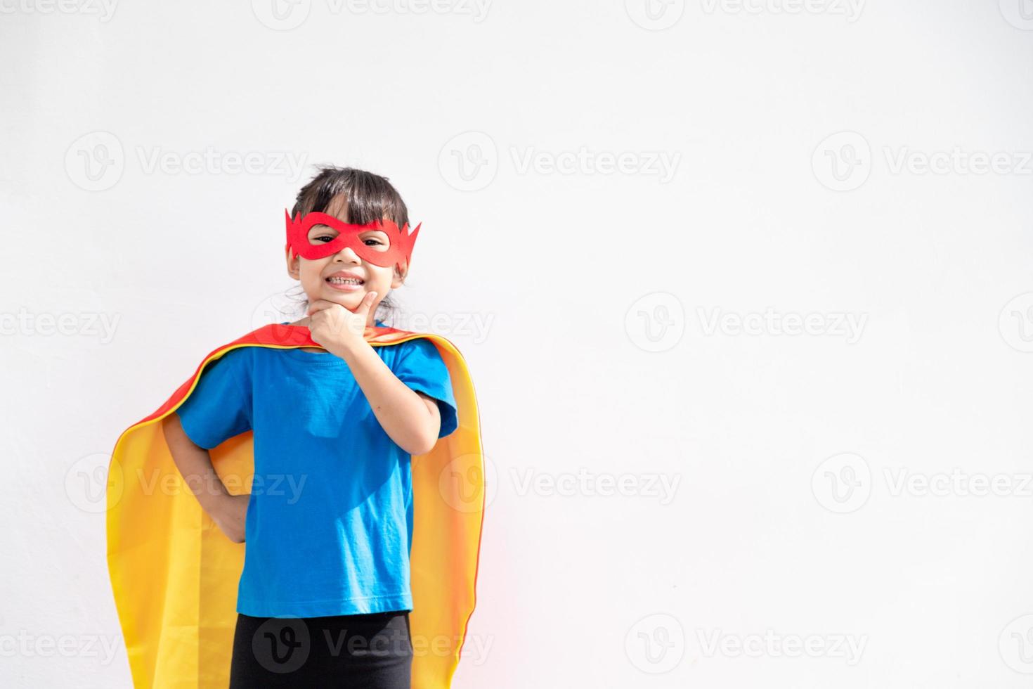 petite fille enfant joue au super-héros. enfant sur le fond blanc. concept de pouvoir des filles photo