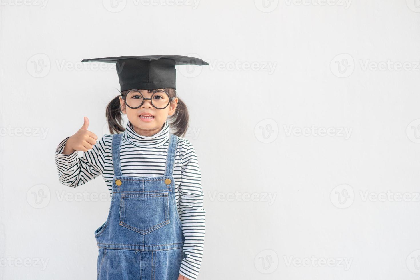 Diplômé d'enfant d'école asiatique heureux avec chapeau de graduation photo