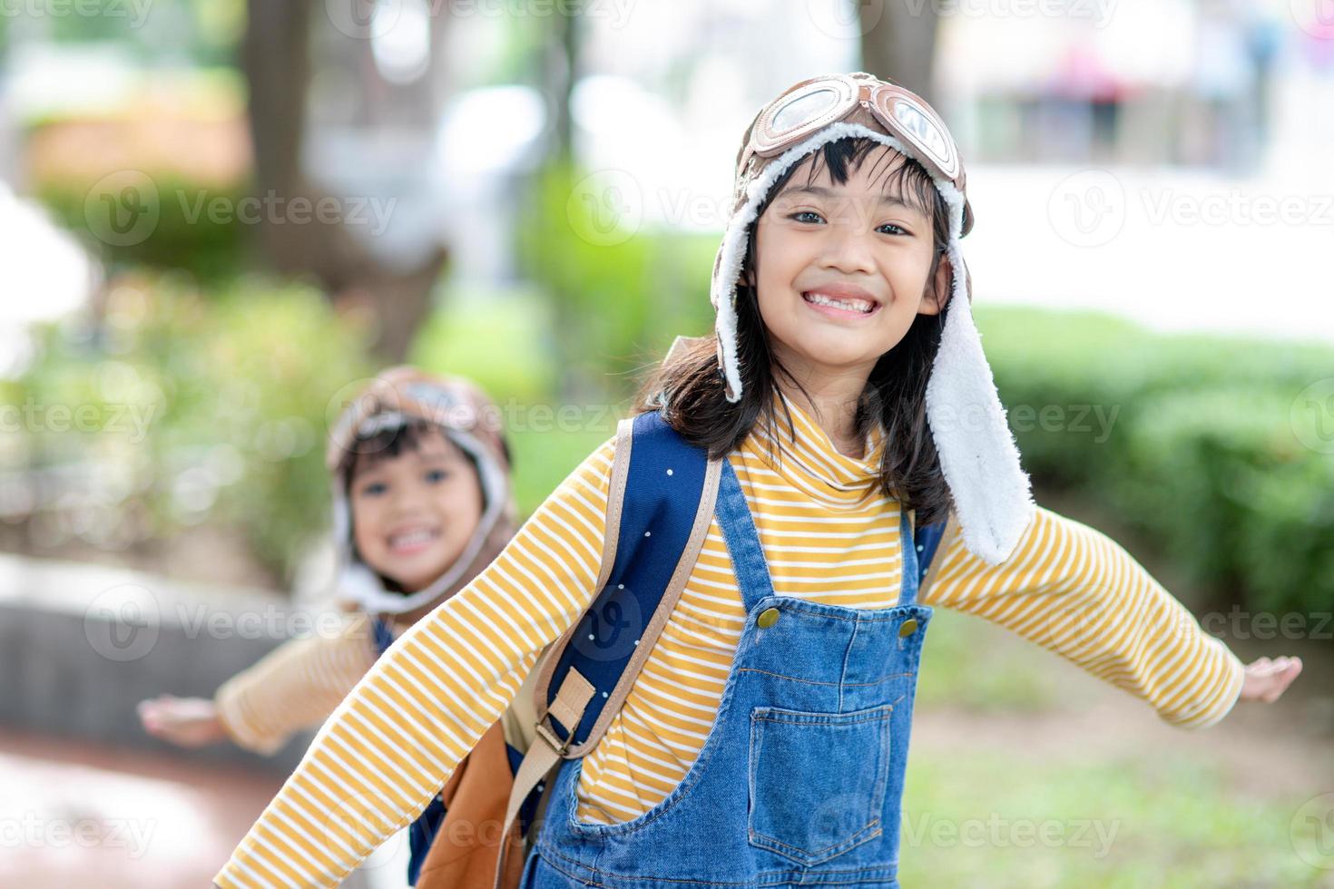 une jolie petite fille vêtue d'une casquette et de lunettes de pilote. l'enfant rêve de devenir pilote. photo