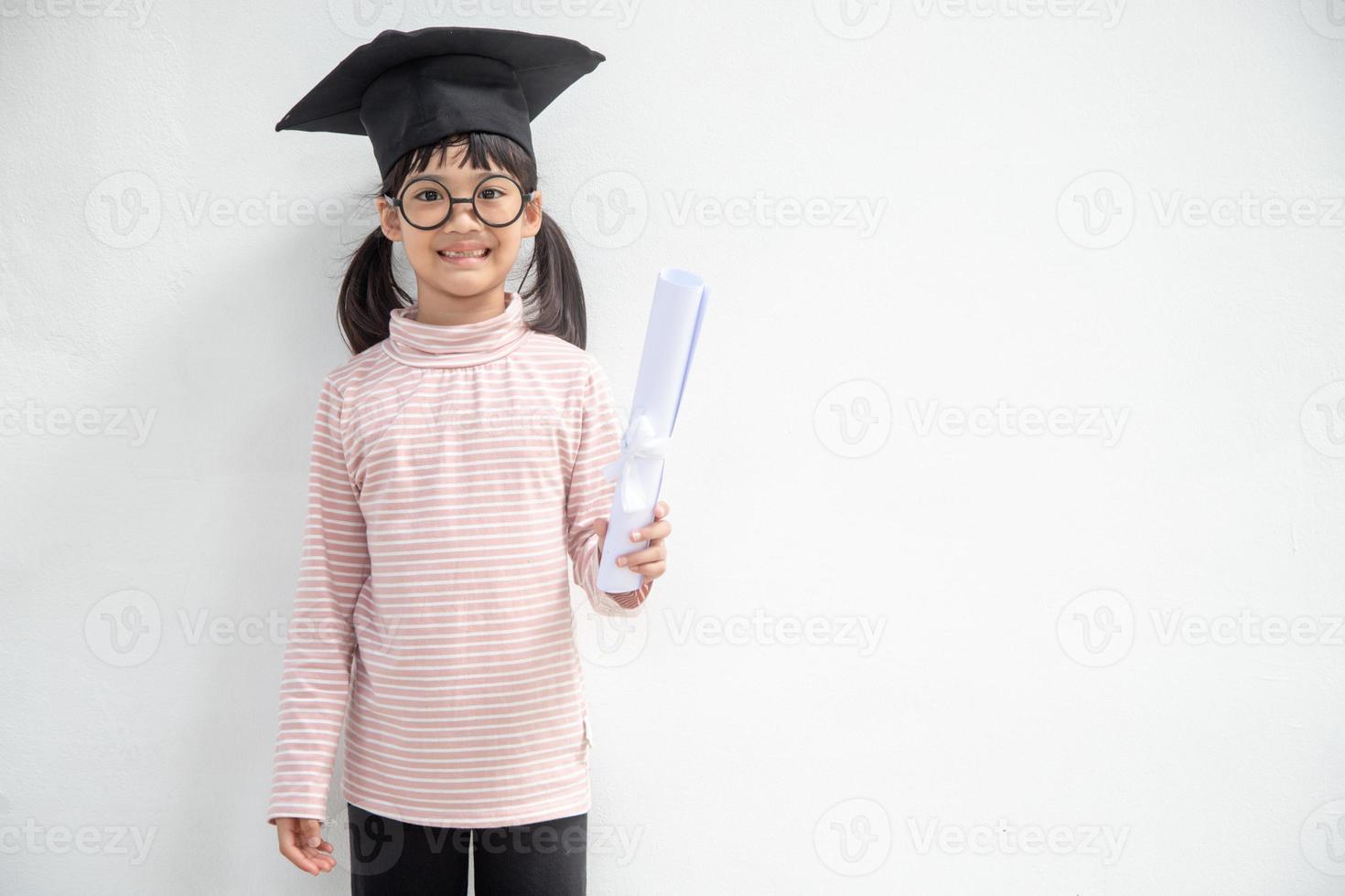 heureux écolier asiatique diplômé en chapeau de graduation photo