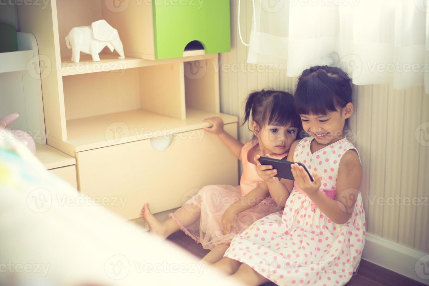 enfants joyeux avec des smartphones dans les mains jouant photo