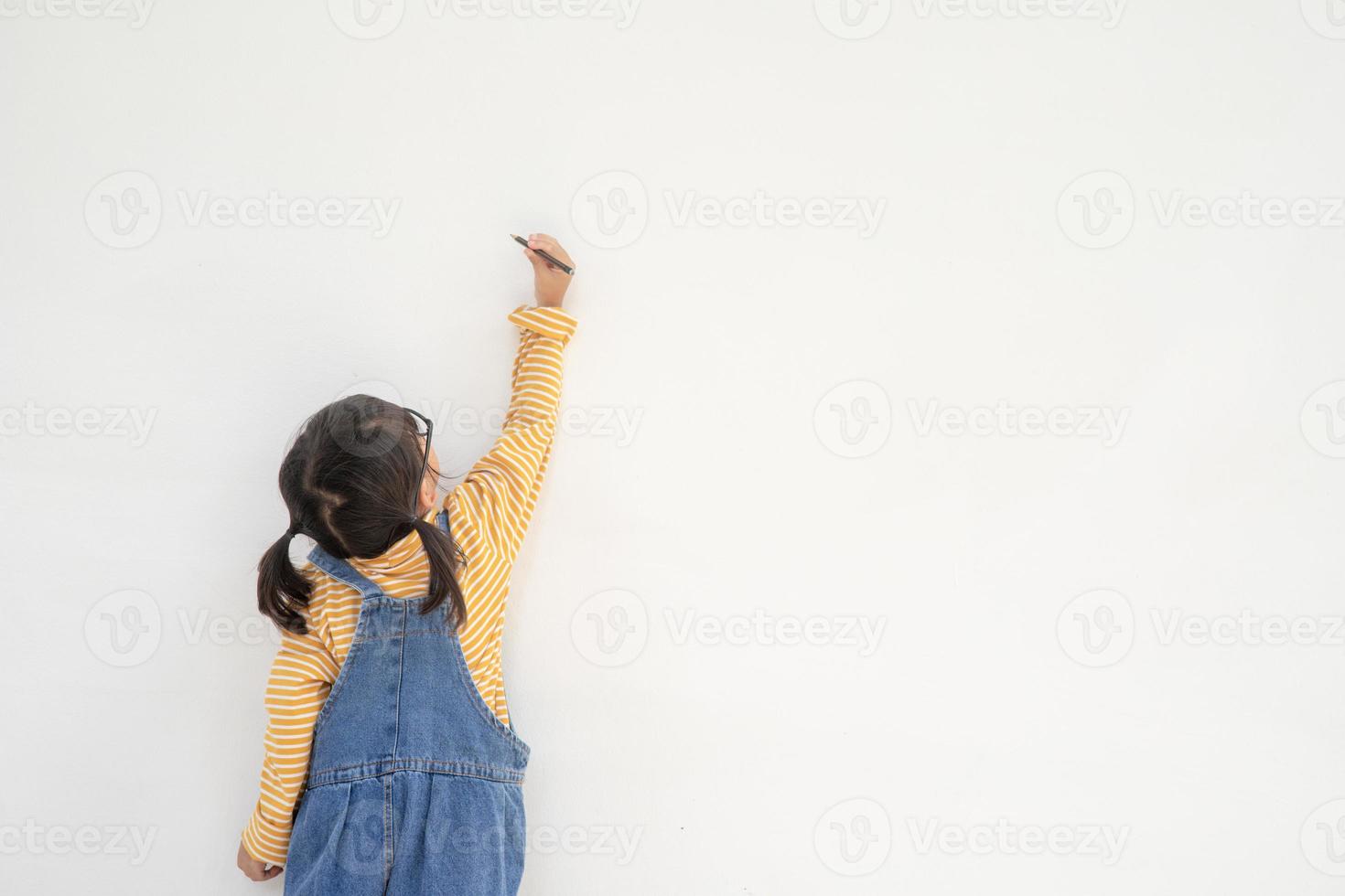 petits enfants peignant sur un mur blanc photo