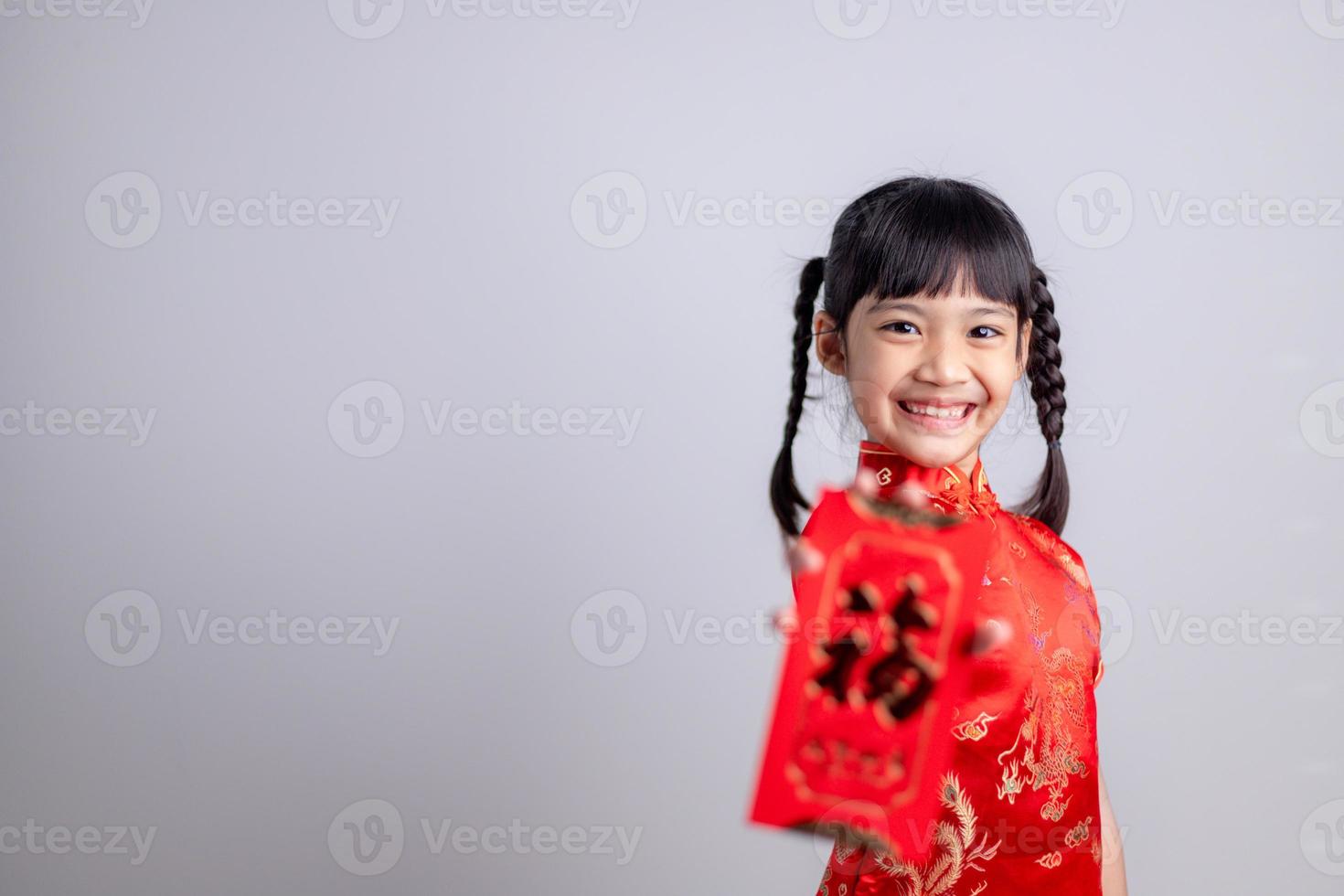 joyeux Nouvel An chinois. petites filles asiatiques souriantes tenant une enveloppe rouge photo