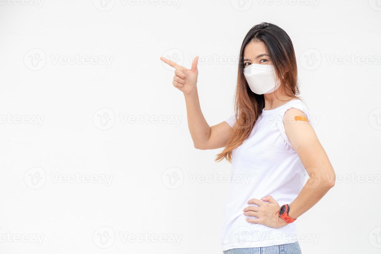 les femmes asiatiques montrent un bandage sur le bras. une femme asiatique heureuse se sent bien après avoir reçu le vaccin sur fond blanc. photo