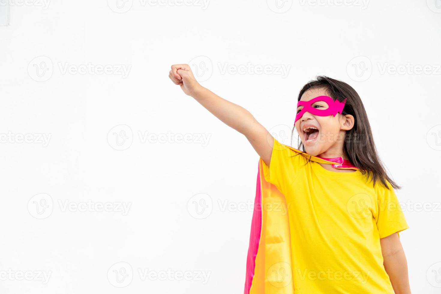 drôle de petite fille jouant au super héros de puissance sur fond blanc. notion de super-héros. photo