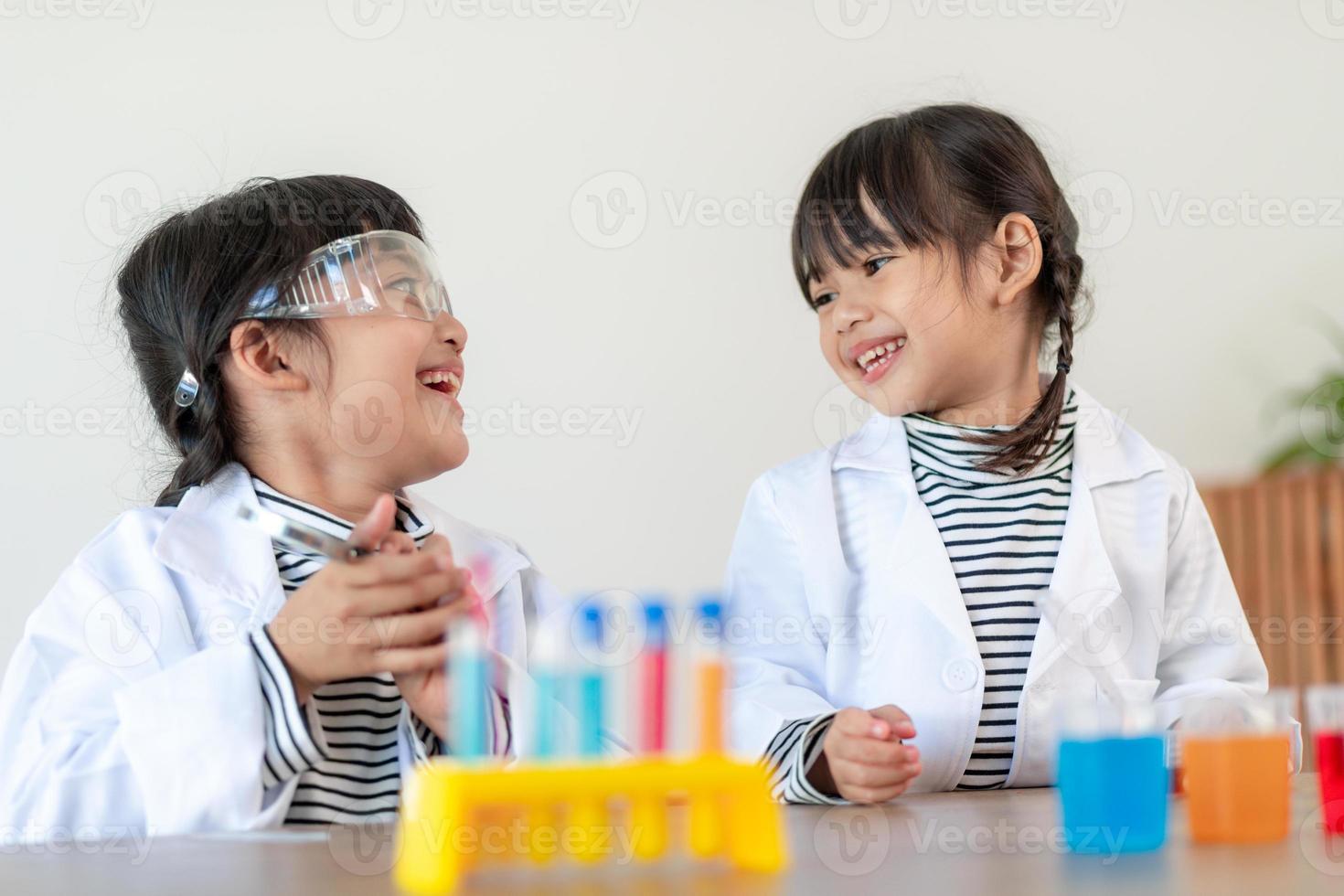 concept d'éducation, de science, de chimie et d'enfants - enfants ou étudiants avec expérience de fabrication de tubes à essai au laboratoire de l'école photo