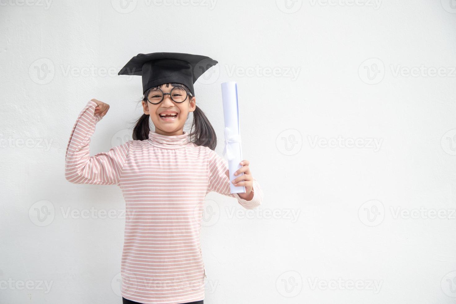 heureux écolier asiatique diplômé en chapeau de graduation photo