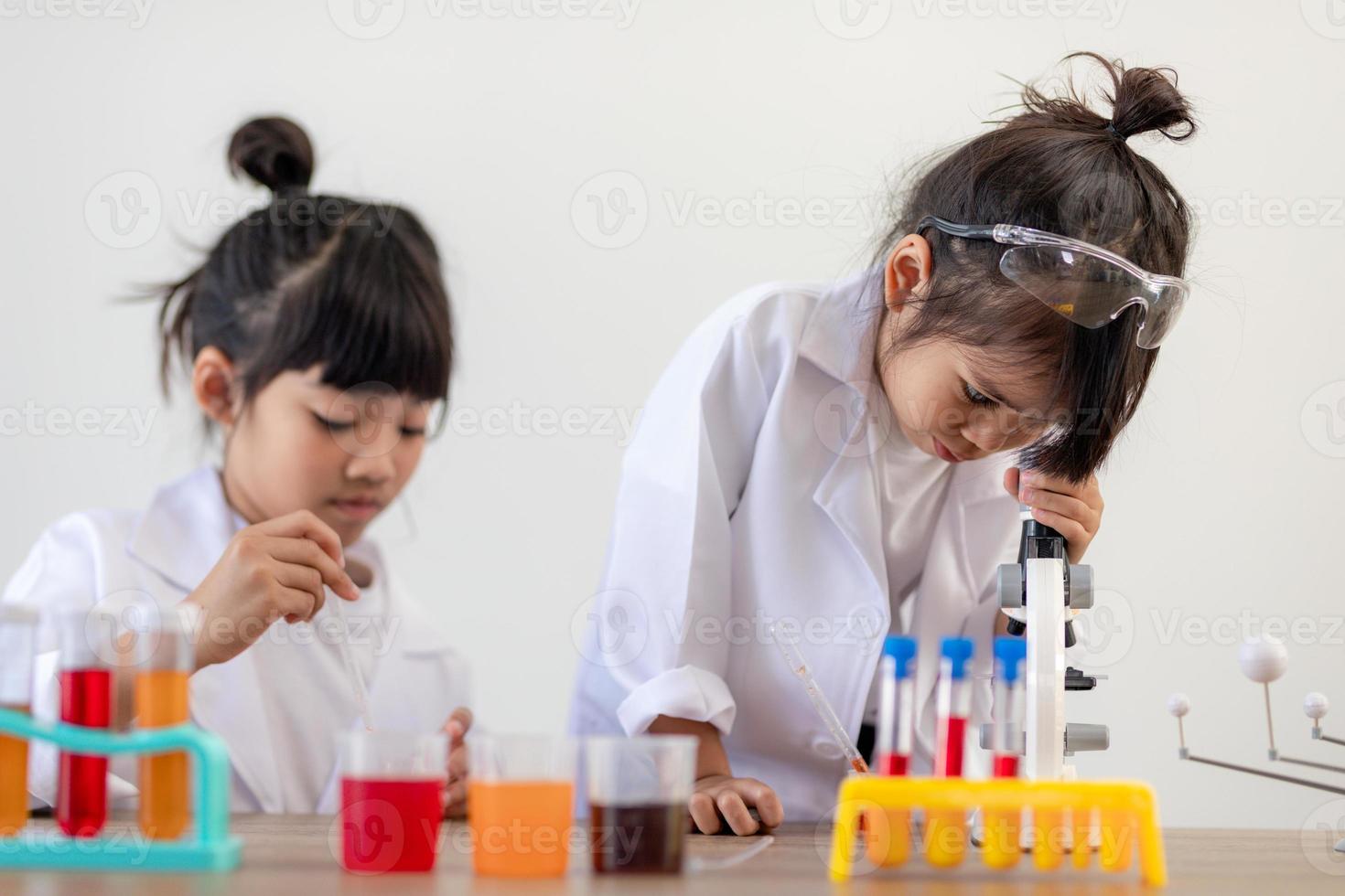 concept d'éducation, de science, de chimie et d'enfants - enfants ou étudiants avec expérience de fabrication de tubes à essai au laboratoire de l'école photo