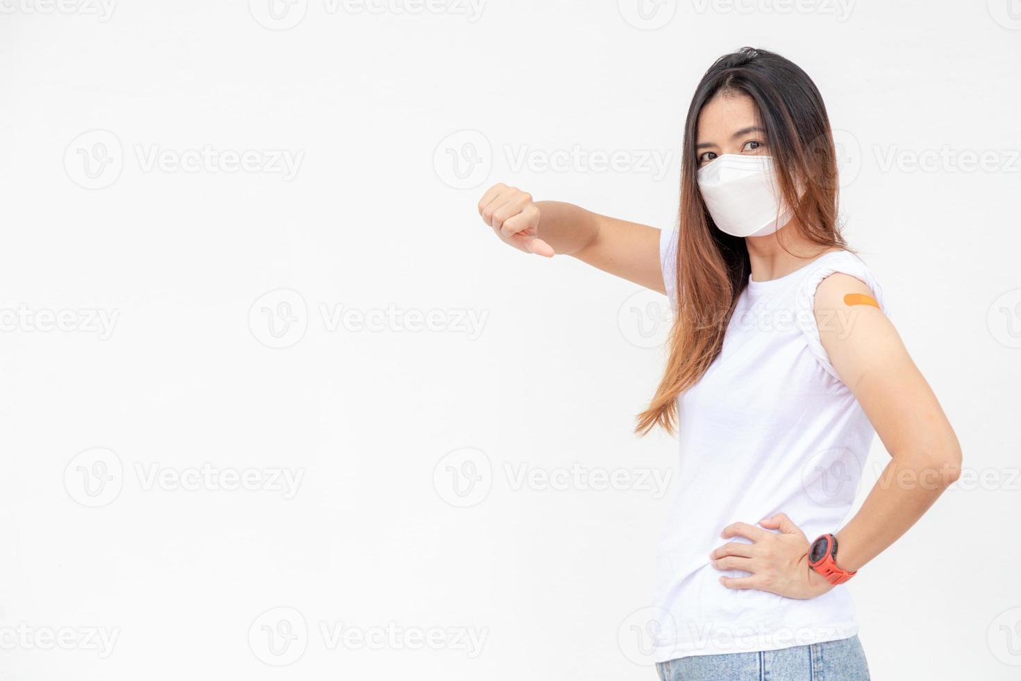 les femmes asiatiques montrent un bandage sur le bras. une femme asiatique heureuse se sent bien après avoir reçu le vaccin sur fond blanc. photo