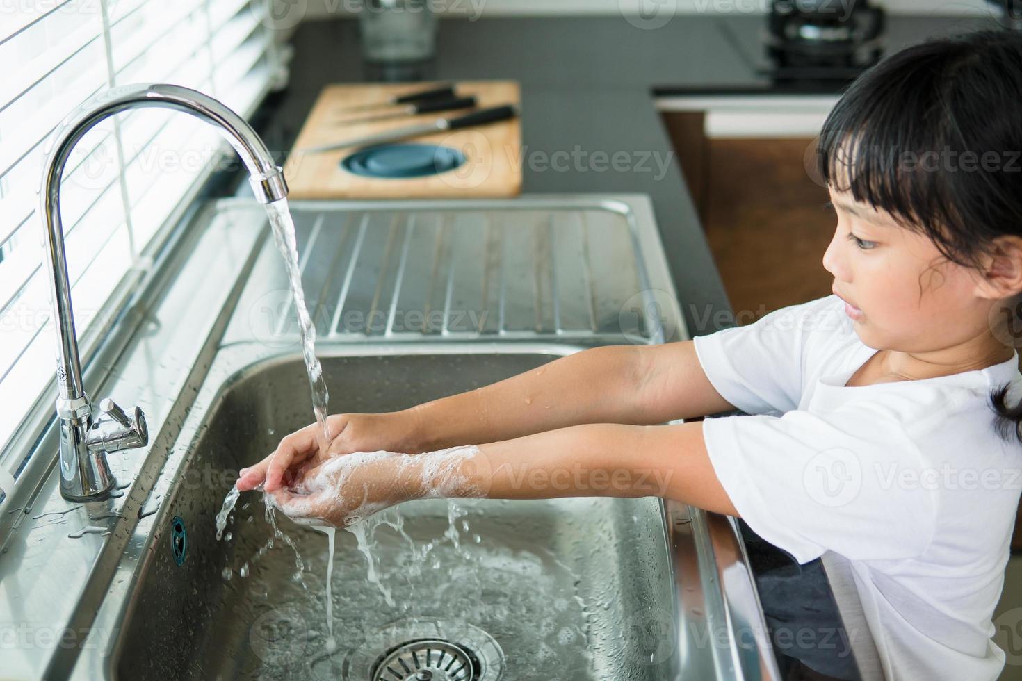 enfant se lavant les mains avec du savon photo