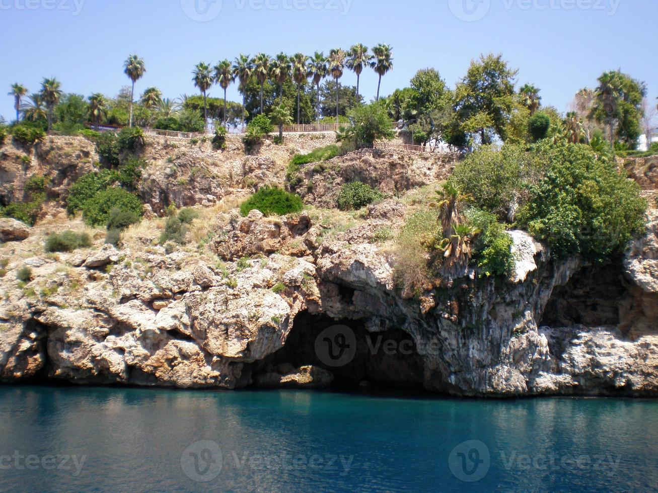 vue sur les falaises de la montagne avec la grotte de la ville d'antalya, turquie photo