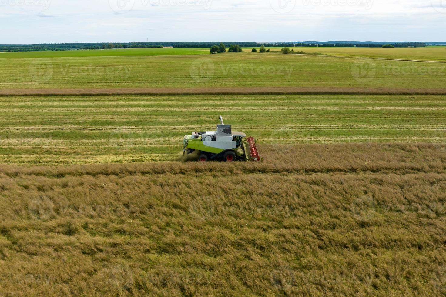 vue aérienne sur les moissonneuses lourdes modernes retirez le pain de blé mûr dans le champ. travail agricole saisonnier photo