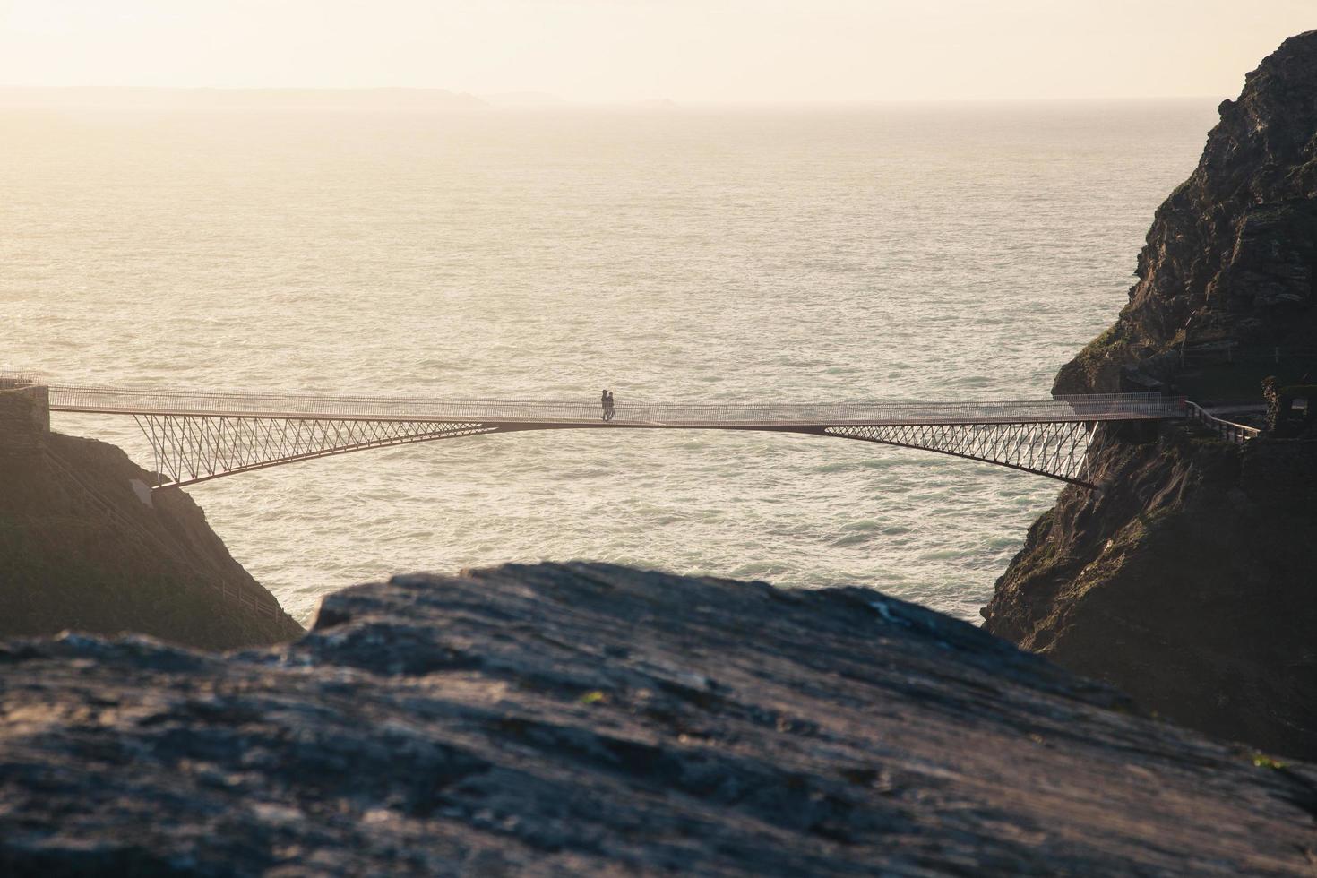 personnes marchant sur un pont à l'heure d'or photo