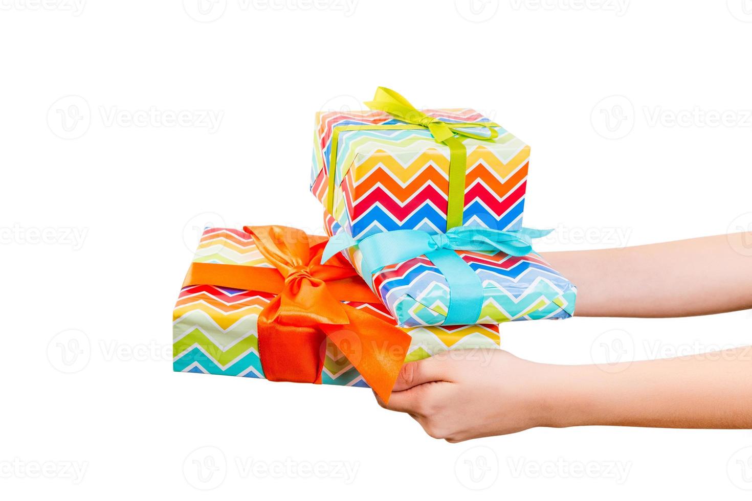 les mains de la femme donnent un ensemble emballé de noël ou d'autres vacances faites à la main dans du papier de couleur avec un ruban vert, orange et bleu. isolé sur fond blanc, vue de dessus. concept de boîte-cadeau d'action de grâces photo