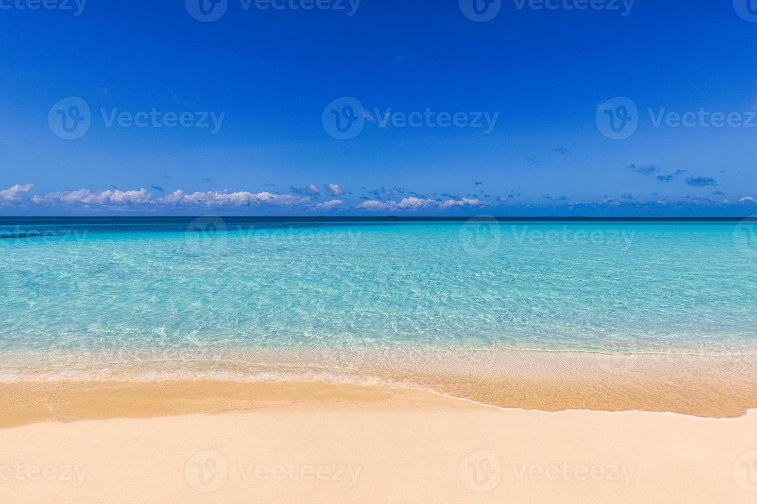 gros plan de sable sur la plage et ciel d'été bleu. paysage de plage panoramique. plage tropicale vide et paysage marin. ciel bleu ensoleillé, sable doux, calme, lumière du soleil relaxante et tranquille, ambiance estivale. rive des vagues photo