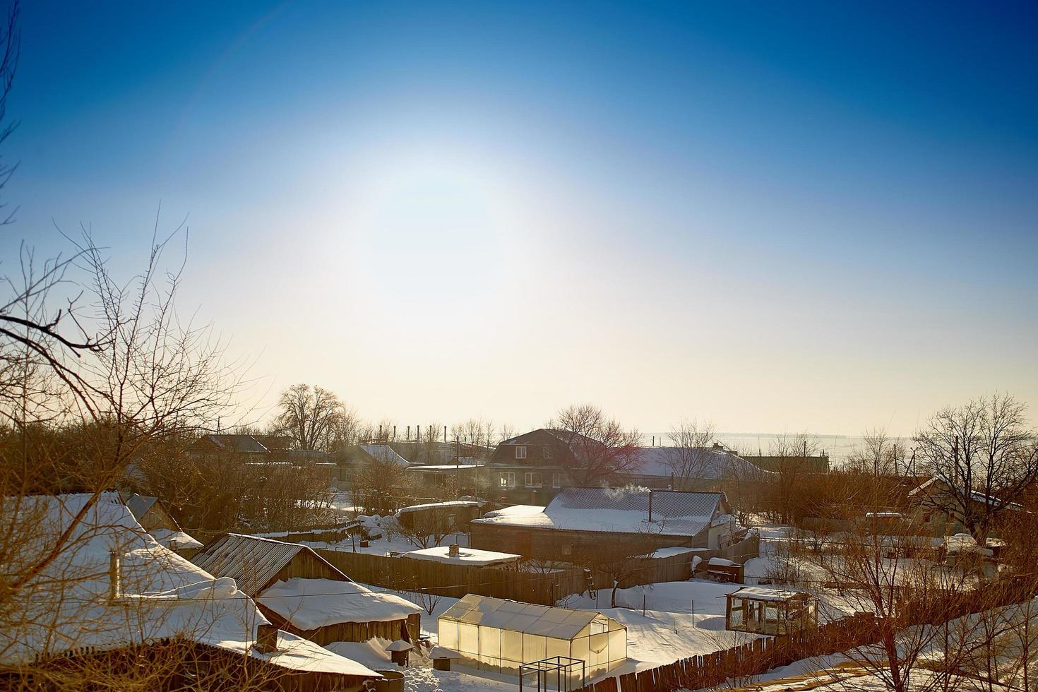 la fumée sort de la cheminée de la maison. le tuyau sur le toit. cheminée. maison de campagne. la maison avec une cheminée. fumer dans le ciel bleu. cheminées et nuages du ciel. photo