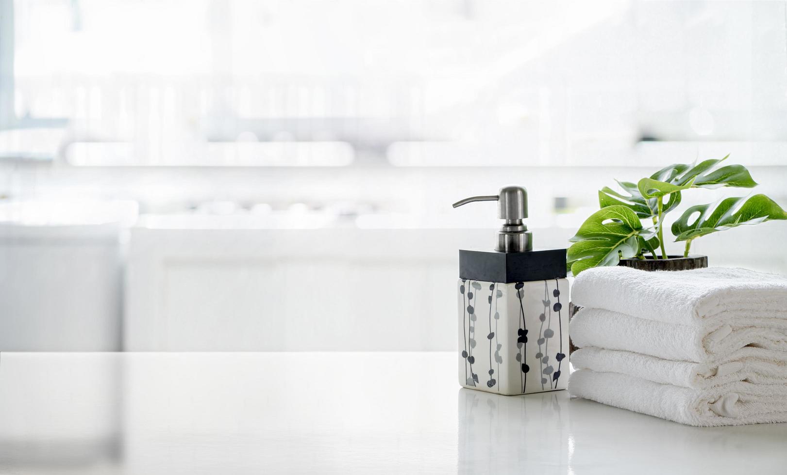bouteille de savon avec des serviettes et une plante sur une table photo