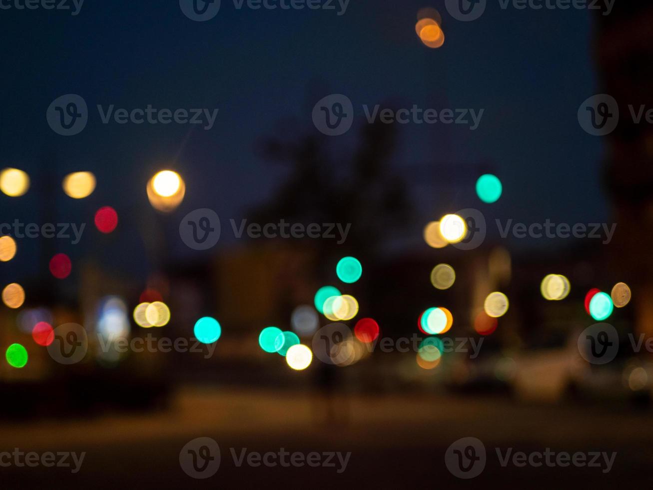 arrière-plan flou. vue floue sur la rue en soirée avec feux de circulation et points de lumières de la ville photo