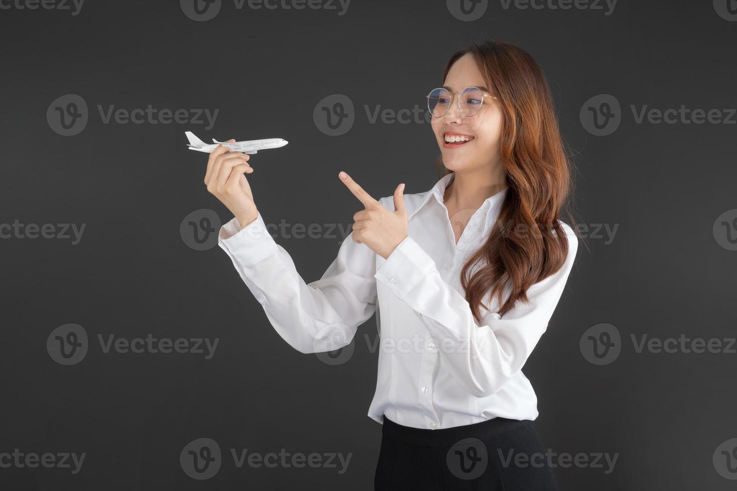 femme d'affaires portant une chemise blanche main tenant un avion jouet blanc. photo