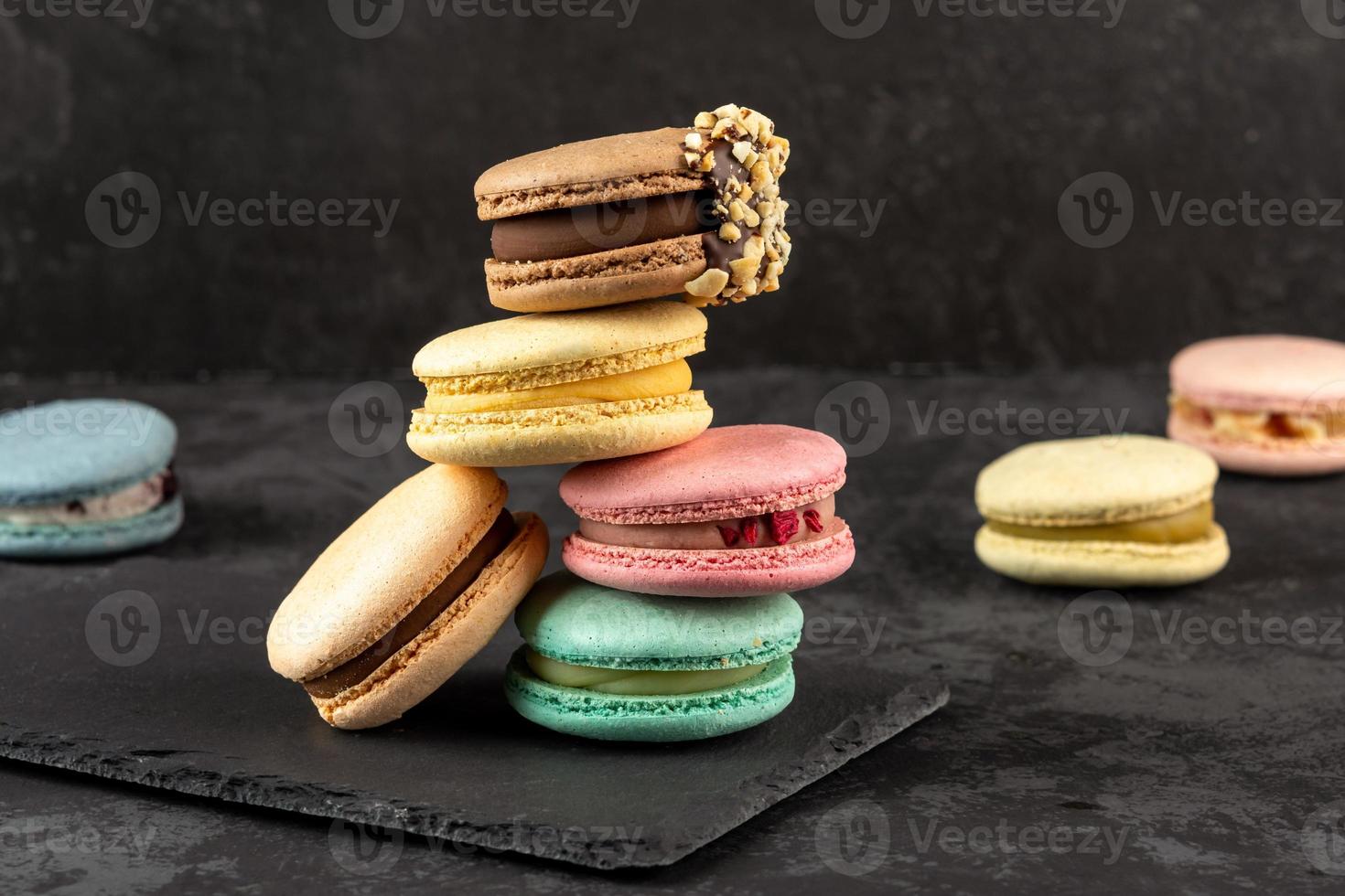 macarons empilés sur un fond sombre. délicieux dessert de cuisine française décoré de façon créative photo